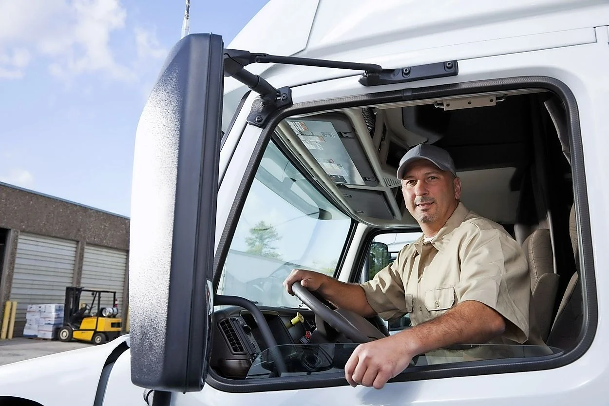 Driver seated at the wheel of a truck cab