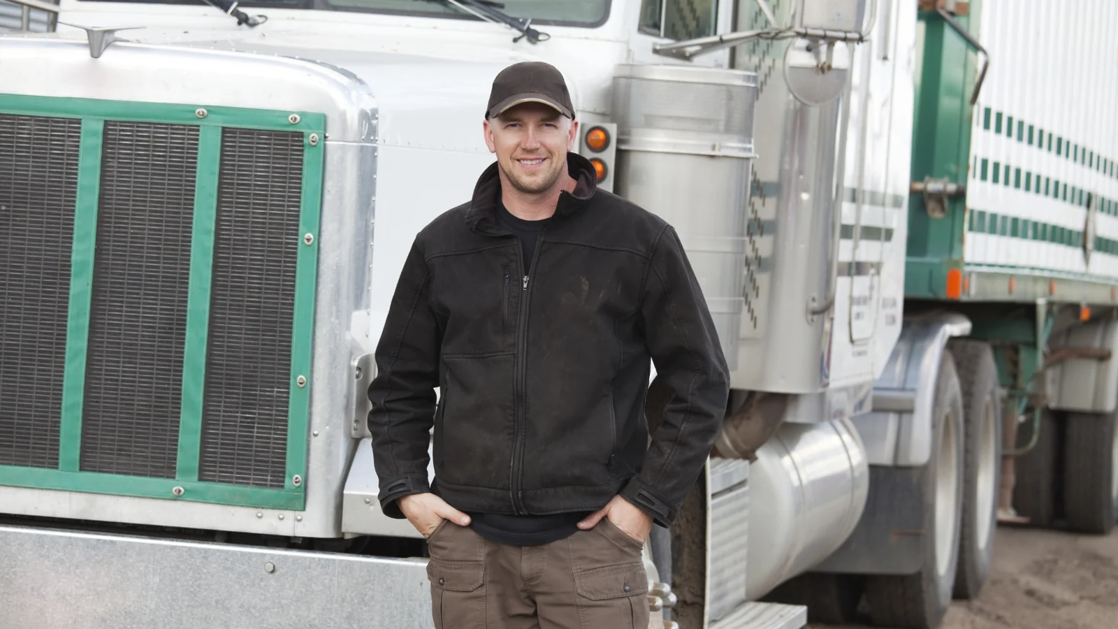 Truck driver standing beside a semi truck